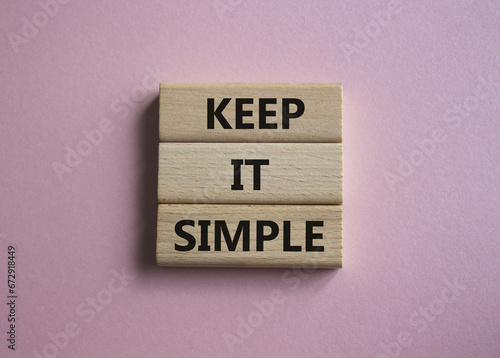 Keep it Simple symbol. Concept words Keep it Simple on wooden blocks. Beautiful pink background. Business and Keep it Simple concept. Copy space.