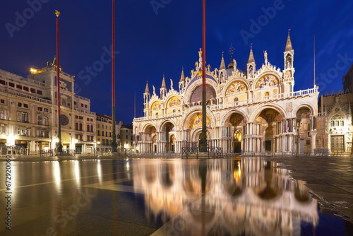 Basilica in San Marco square in Venice with aqua alta reflection at twilight.