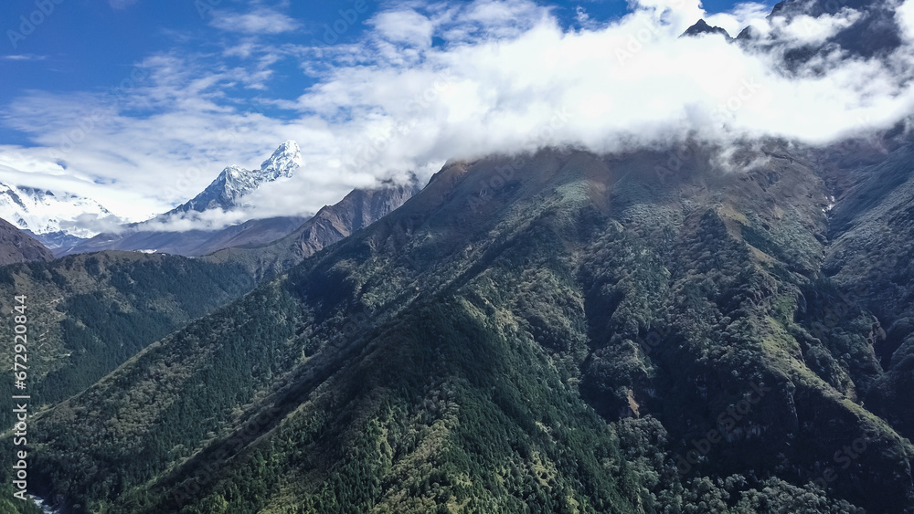 Mountain landscape of Nepal with snowy peaks with clouds in sunny weather