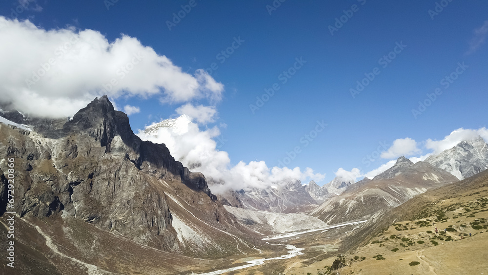 Mountain landscape of Nepal with snowy peaks with clouds in sunny weather
