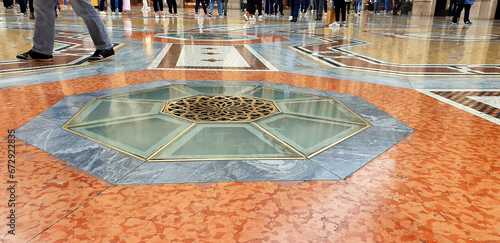 A multicolored marble floor with people walking on it. Milan, Italy. photo