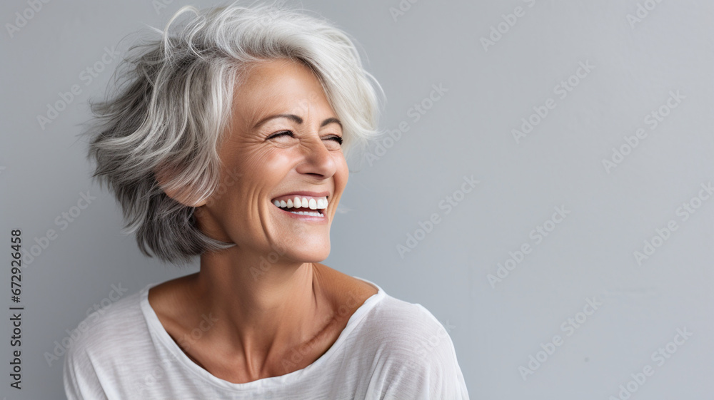 happy woman smiling while standing on gray background - obrazy, fototapety, plakaty 