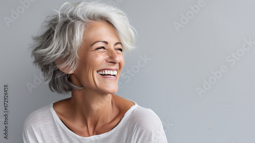 happy woman smiling while standing on gray background