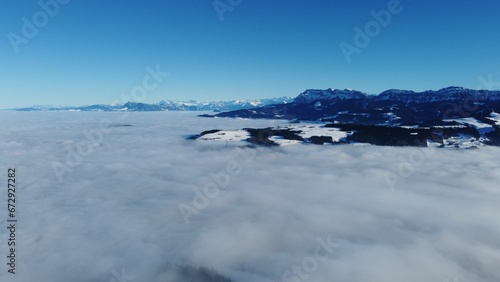 Drone view of a town covered in thick fog under the sunlight and a blue sky