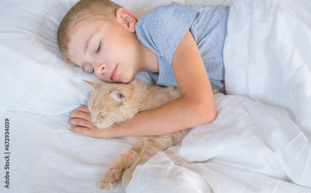 A child in bed cannot fall asleep, yawns, grimaces and plays with a ginger cat.