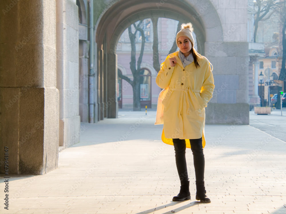 Young woman in yellow jacket in early spring in the city