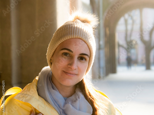 Young woman in yellow jacket in early spring in the city photo