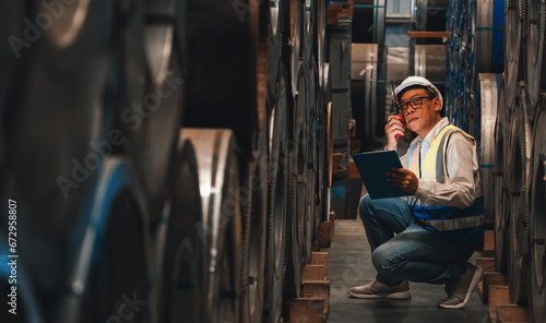 Warehouse inventory management in metalwork factory with engineer or inspector conduct storage check and quality control assessment on cylinder rolled metal for civil engineering project. Exemplifying photo