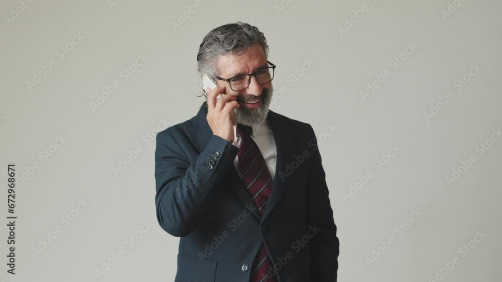 Happy businessman talking on smartphone, isolated on gray background Happy businessman talking on smartphone, isolated on gray background