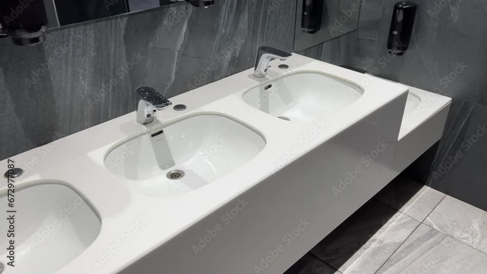 Rows of modern washbasins in a public restroom Rows of modern washbasins in a public restroom