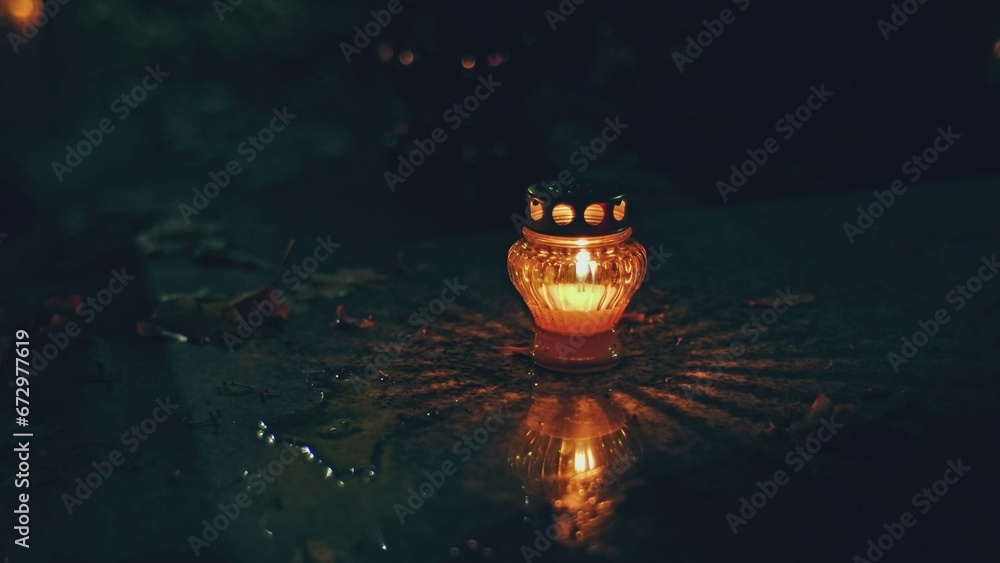 Anonymous Person Putting Lit Vigil Candle Lantern on Cemetery Grave Tombstone All Saints Day Evening - obrazy, fototapety, plakaty 