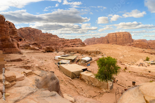 Fényképezés Mountain, high angle panoramic view above a small Bedouin market and encampment overlooking the ancient Nabatean Rose City of Petra, in the Southwestern desert of Jordan