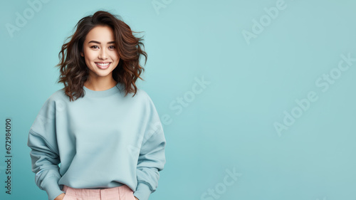 An Asian woman wearing blue sweatshirt isolated on pastel background photo