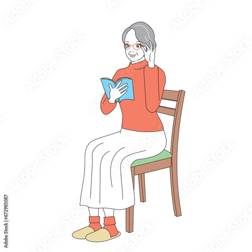 椅子に腰掛け読書をする上品なシニア女性