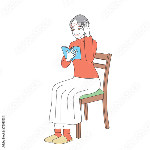 椅子に腰掛け読書をする上品なシニア女性