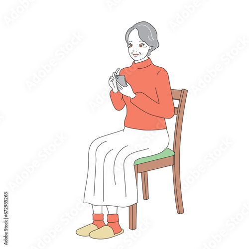 椅子に腰掛けスマートフォンを操作する上品なシニア女性
