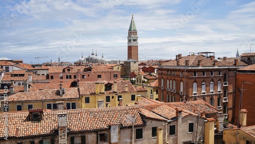 Impressive campanile stands majestically above picturesque Venetian buildings. Italy.