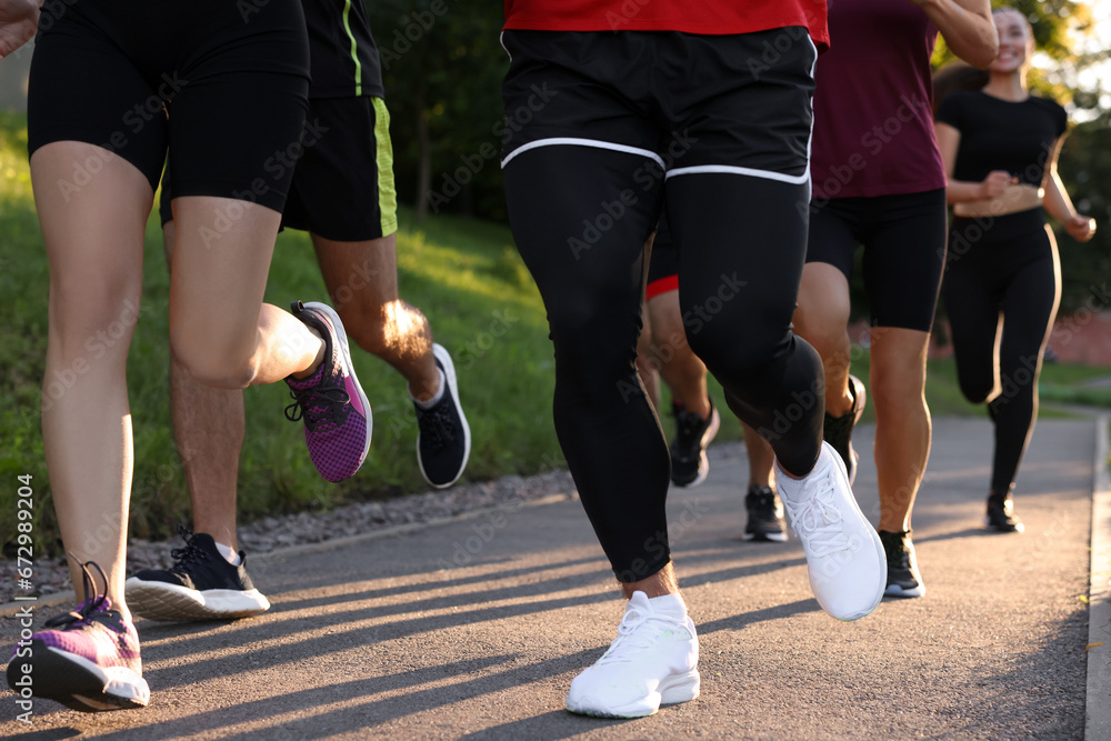 Fototapeta premium Group of people running outdoors, closeup view