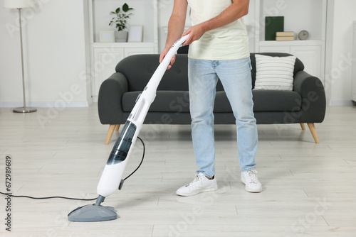 Man cleaning floor with steam mop at home, closeup