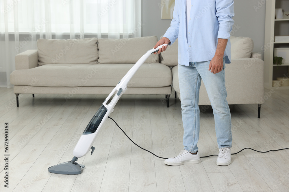 Man cleaning floor with steam mop at home, closeup Man cleaning floor with steam mop at home, closeup