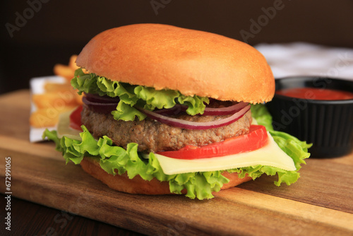 Tasty burger with vegetables, patty and cheese on table, closeup