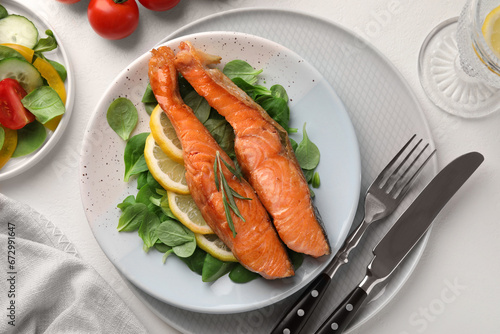 Healthy meal. Pieces of grilled salmon, spinach, lemon and rosemary served on white table, flat lay