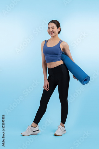 Young attractive asian woman portrait in sportswear with exercising mat. Healthy exercise and workout routine lifestyle concept. Studio shot isolated background. Vigorous