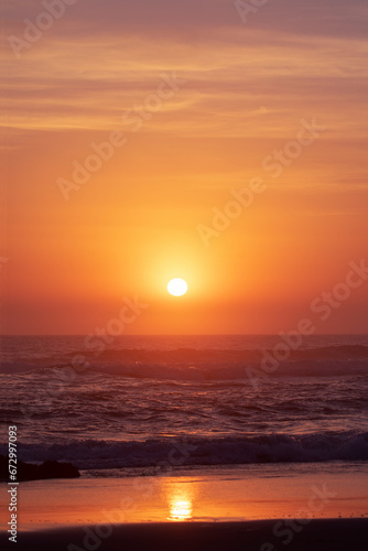 Beach view with colourful orange sunlit sky and ocean waves. Gold Coast Australia