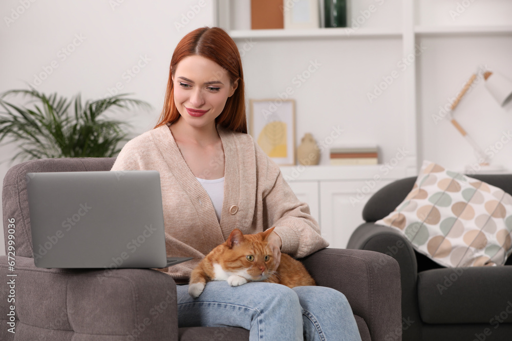 Woman with cat working in armchair at home, space for text Woman with cat working in armchair at home, space for text