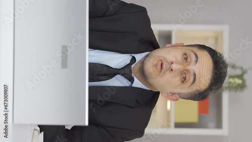 Vertical video of Home office worker man nods to the camera, says no, no.