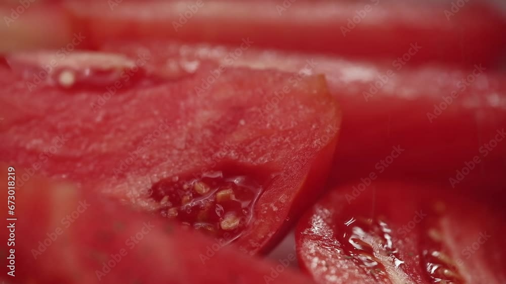 close up chef sprinkles dried basil on slices of fresh ripe red tomatoes in the vegetable dryer. process of cooking sun dried tomatoes. close up chef sprinkles dried basil on slices of fresh ripe red tomatoes in the vegetable dryer. process of cooking sun dried tomatoes.