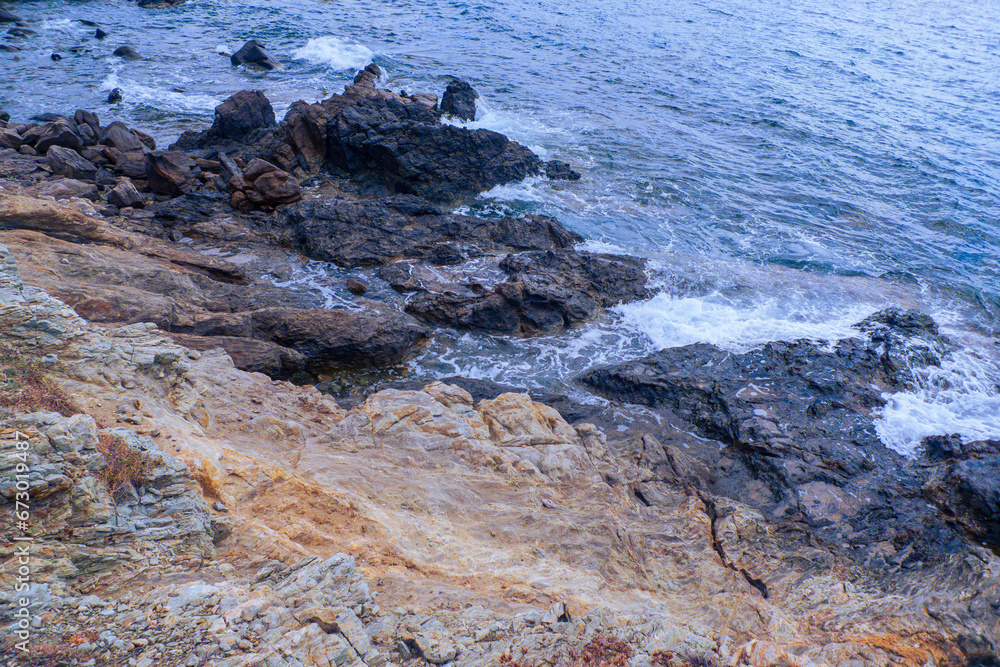 Rocks of the shoreline in Mykonos, Greece. Ocean, coastline, rock texture. Rocks of the shoreline in Mykonos, Greece. Ocean, coastline, rock texture.