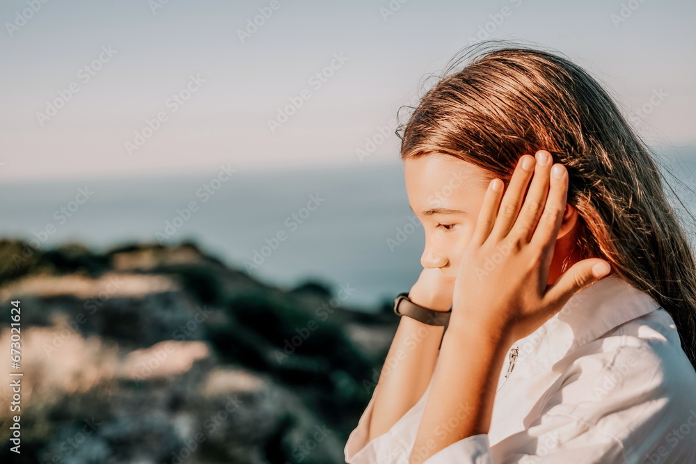 Adorable teenage girl outdoors enjoying sunset at beach on summer day. Close up portrait of smiling young romantic teenager girl with long hair on beach at summer evening. Travel and holidays