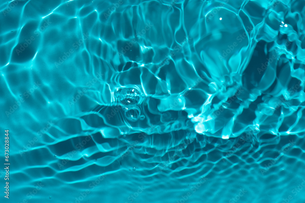 Defocus blurred transparent blue colored clear calm water surface texture with splashes reflection. Trendy abstract nature background. Water waves in sunlight with copy space. Blue watercolor shine. Defocus blurred transparent blue colored clear calm water surface texture with splashes reflection. Trendy abstract nature background. Water waves in sunlight with copy space. Blue watercolor shine.