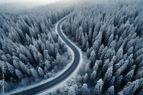 Aerial curved road in the winter season with snow covering on surrounded trees on the mountains. © Golden House Images