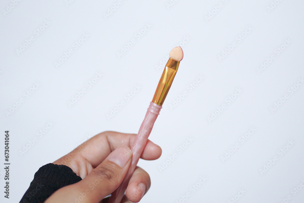 Hand model holding a a set of makeup brushes with a white background for cosmetic advertising Hand model holding a a set of makeup brushes with a white background for cosmetic advertising