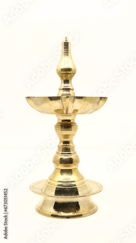 a vintage, brass oil lamp of unique traditional design used for temple celebration and festival rituals, also called as diya, vilakku or samai isolated
