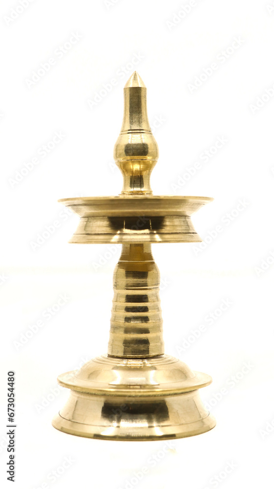 traditional gold oil lamp or vilakku or samai with a clean shiny surface used as antique decoration and for religious ceremonies isolated in a white background traditional gold oil lamp or vilakku or samai with a clean shiny surface used as antique decoration and for religious ceremonies isolated in a white background