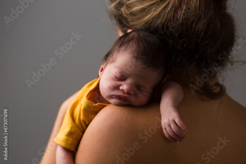 Newborn sleeping over her mother