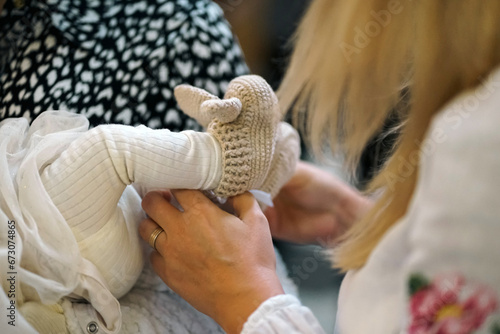 Valokuva The legs of a newborn during church baptism.