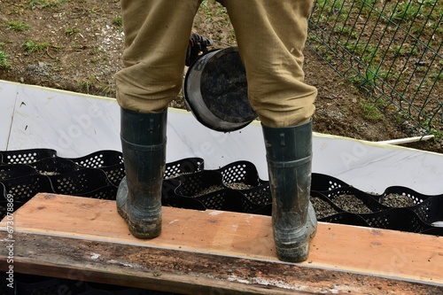 Obraz na płótnie Pouring crushed stone into the plastic net and compacting the plastic net with mesh w salonie