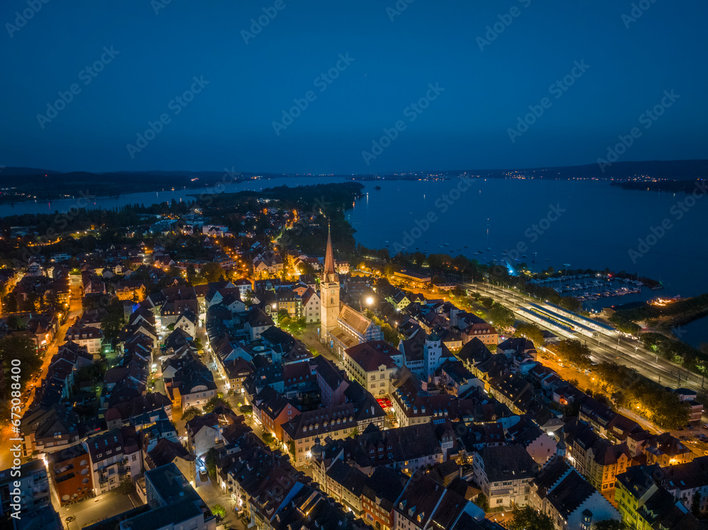 Luftbild von der Stadt Radolfzell am Bodensee bei Nacht mit dem angestrahlten Münsterturm