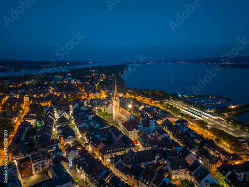 Luftbild von der Stadt Radolfzell am Bodensee bei Nacht mit dem angestrahlten Münsterturm