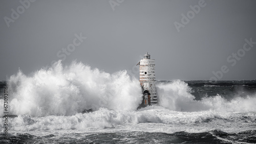 Lighthouse storm - mangiabarche lighthouse during a winter swell in Calasetta in southern Sardinia