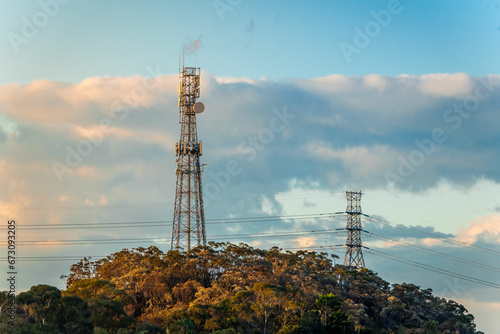 Mobile tower and power lines installation, cell site and telecom base station. 5G internet online generation.