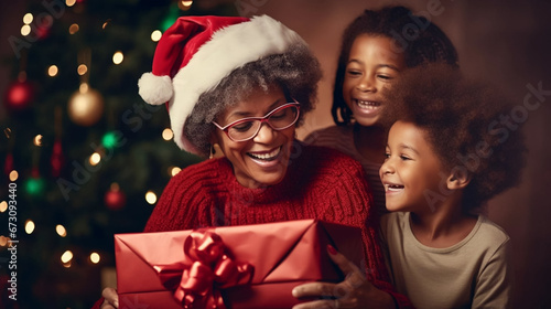 copy space, stockphoto, afro american grandmother with grandchildren celebrating christmas, opening presents. Portrait of a happy grandmother with her grandchildren during Christmas time. Togetherness