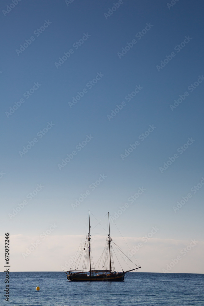 Wooden boat with two masts at anchor