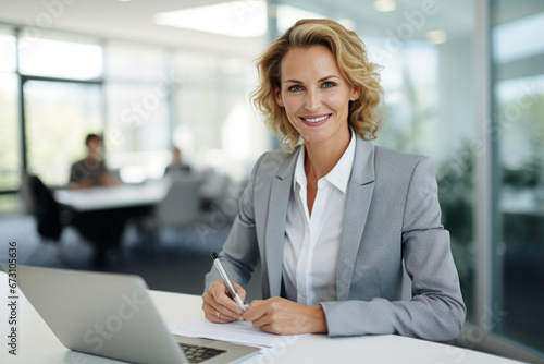 Blonde business woman working with her laptop photo