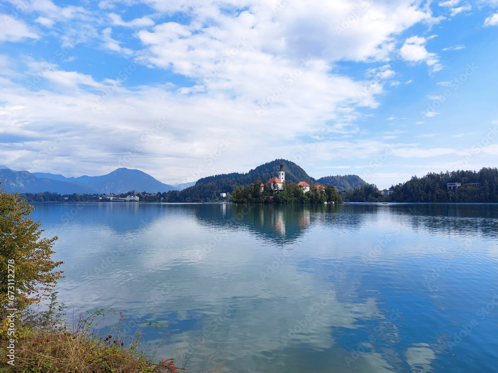 island with white church and clouds on blue sky. Lake Bled. Slovenia.