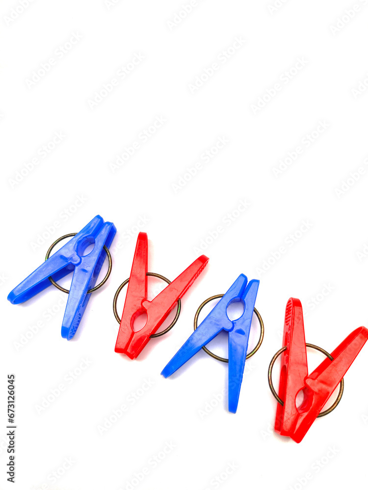 red and blue plastic clothespins are arranged in a row against a white background red and blue plastic clothespins are arranged in a row against a white background